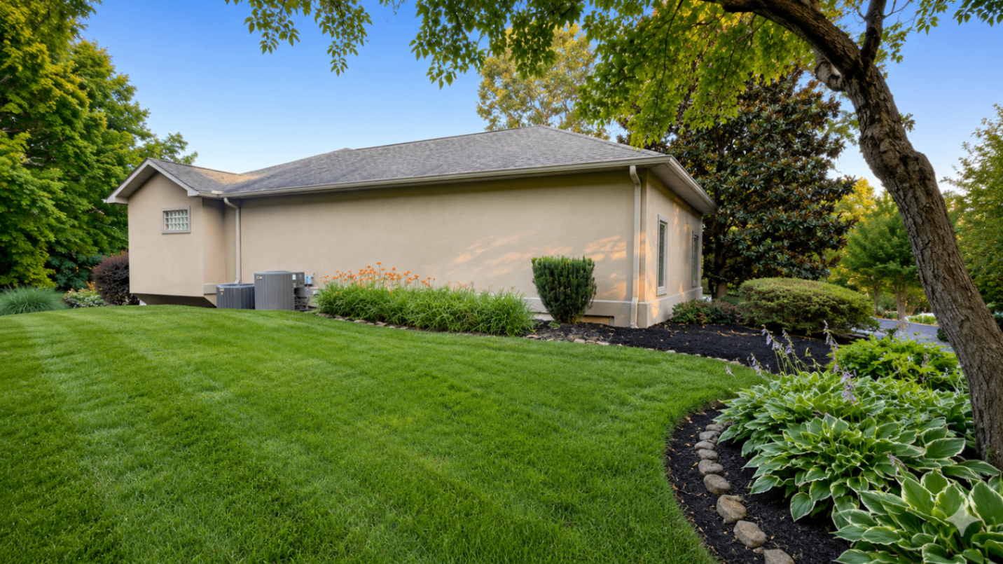 Side yard with dense green turf, mulched border, and hosta plantings